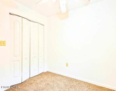 unfurnished bedroom featuring a ceiling fan, baseboards, a closet, and carpet floors