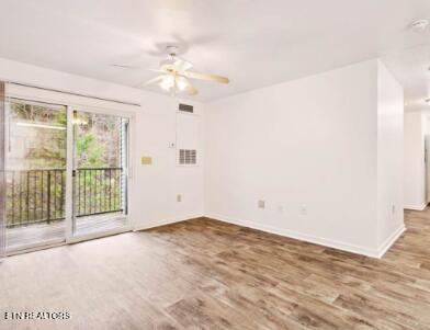 unfurnished room with ceiling fan, visible vents, baseboards, and wood finished floors