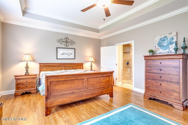 bedroom with light wood-type flooring, a raised ceiling, and ornamental molding