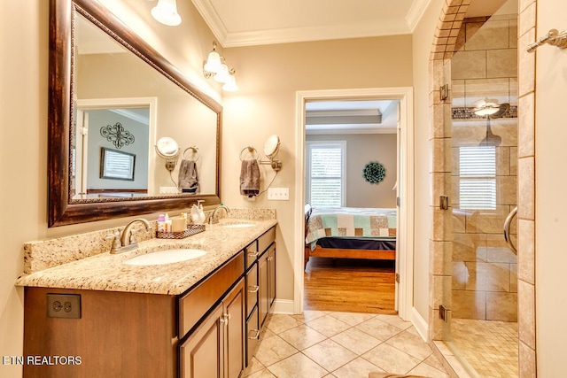 full bathroom featuring tile patterned floors, double vanity, crown molding, and a sink