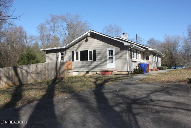 view of side of property with fence and a chimney