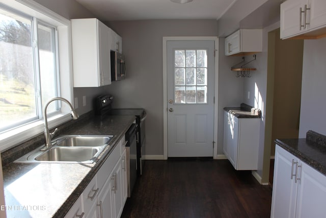 kitchen with a sink, dark wood-type flooring, appliances with stainless steel finishes, and a healthy amount of sunlight