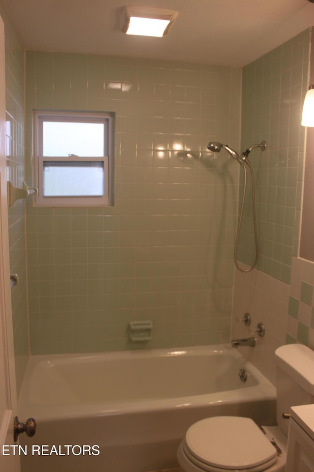 bathroom featuring toilet, shower / washtub combination, and vanity