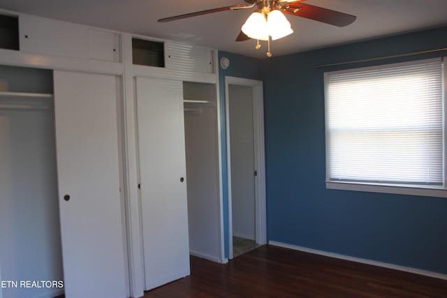 unfurnished bedroom featuring baseboards, dark wood finished floors, and a ceiling fan