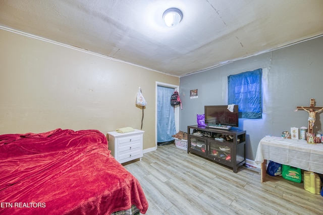 bedroom with wood finished floors and baseboards