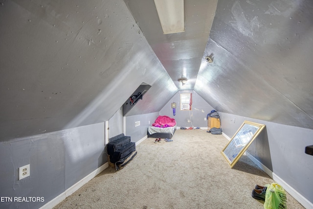 unfurnished bedroom with carpet flooring, baseboards, and vaulted ceiling