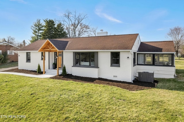 ranch-style home with a chimney, a front lawn, and a shingled roof