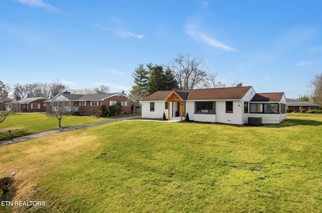 view of front of property featuring a front yard, central AC unit, and driveway