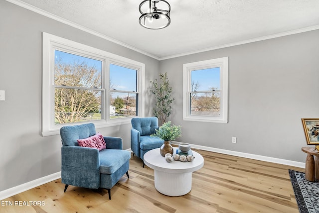 living area featuring baseboards, a notable chandelier, wood finished floors, and crown molding