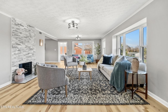 living room with a textured ceiling, plenty of natural light, wood finished floors, and ornamental molding