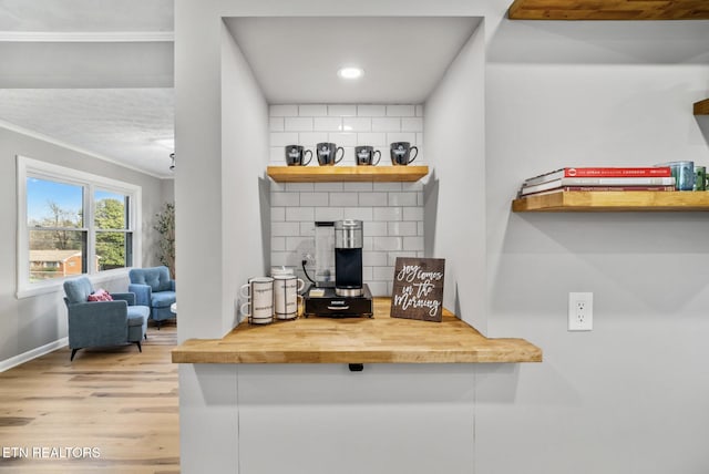 interior space featuring wood finished floors, baseboards, a fireplace, recessed lighting, and ornamental molding