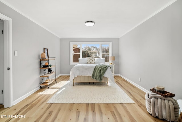 bedroom with baseboards, light wood-type flooring, and ornamental molding