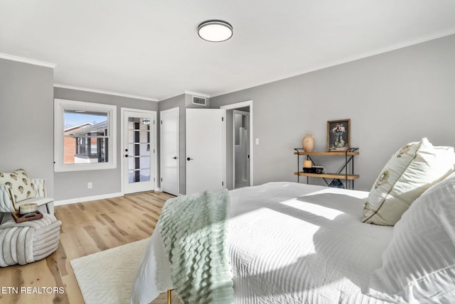 bedroom featuring baseboards, wood finished floors, visible vents, and ornamental molding