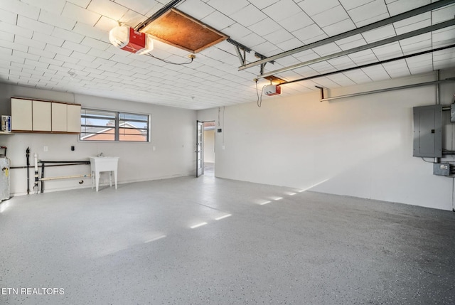 garage with electric panel, a garage door opener, and a sink