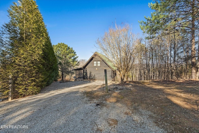 view of front of home with log exterior and gravel driveway