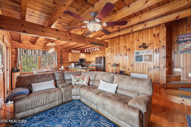 living area with visible vents, wood ceiling, and wooden walls