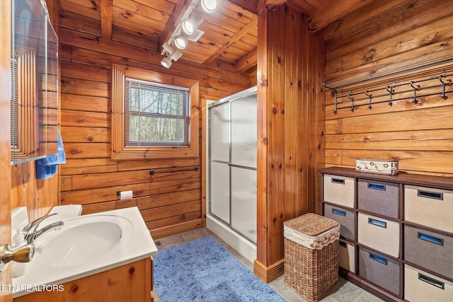 bathroom with beam ceiling, wooden ceiling, a shower stall, wood walls, and vanity