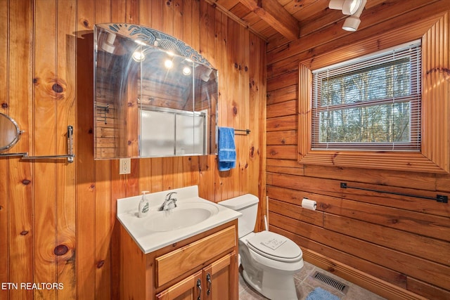 full bathroom with vanity, visible vents, a shower stall, wood walls, and toilet