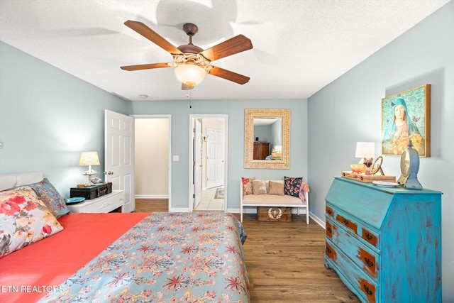 bedroom featuring ceiling fan, baseboards, a textured ceiling, and wood finished floors