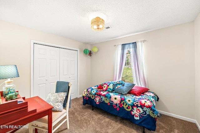 bedroom with a closet, baseboards, carpet, and a textured ceiling