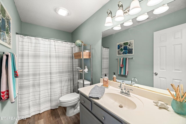 bathroom featuring curtained shower, toilet, wood finished floors, and vanity