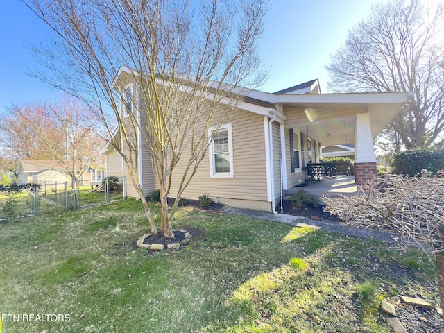 view of home's exterior featuring a gate, a lawn, and fence