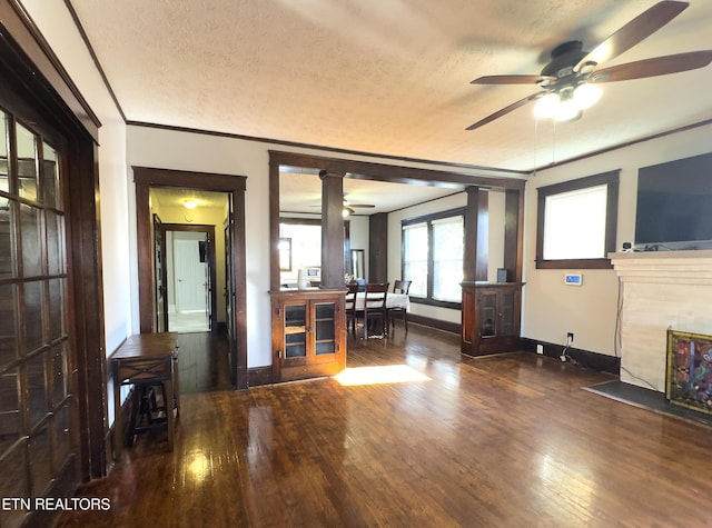 unfurnished living room featuring baseboards, wood-type flooring, a textured ceiling, and a fireplace with flush hearth