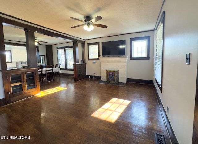 unfurnished living room featuring a brick fireplace, baseboards, and hardwood / wood-style floors