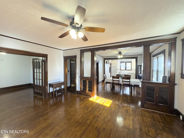 dining area with baseboards, wood finished floors, crown molding, and ornate columns