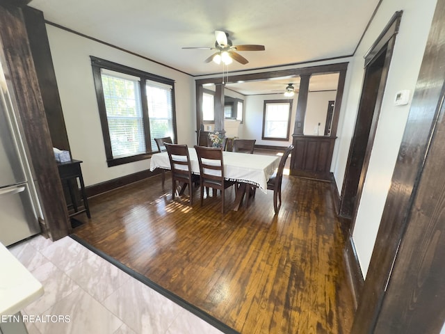 dining room featuring baseboards, hardwood / wood-style floors, a ceiling fan, and ornamental molding