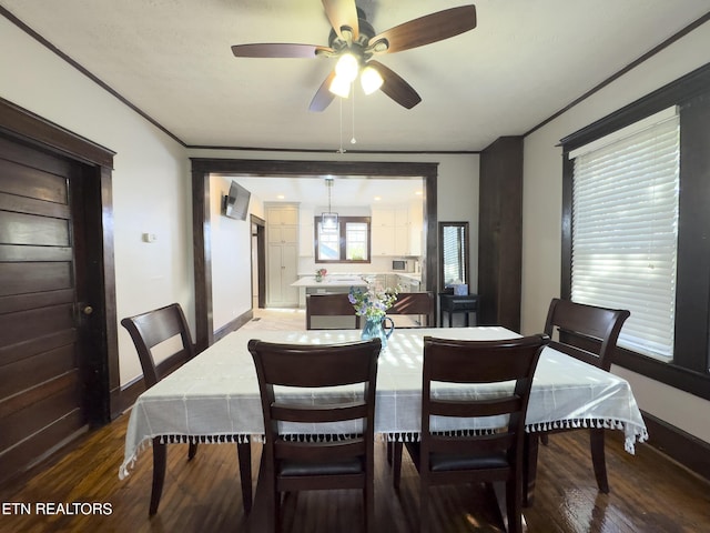 dining room featuring a ceiling fan, baseboards, and wood finished floors