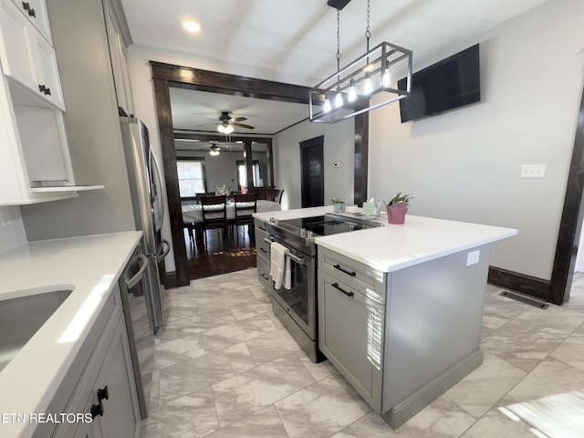 kitchen featuring gray cabinets, a kitchen island, appliances with stainless steel finishes, light countertops, and hanging light fixtures