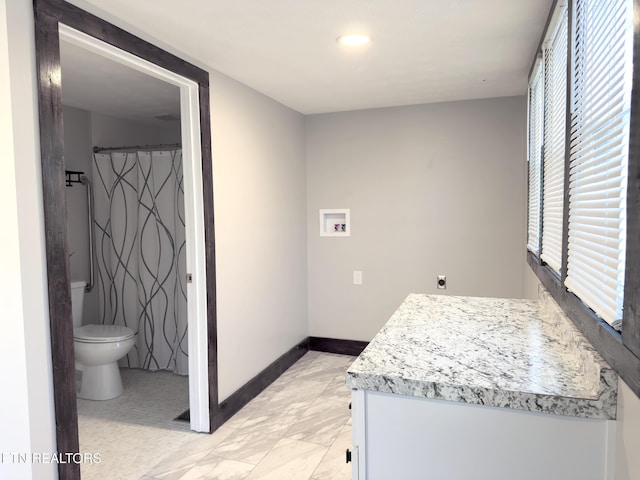 full bath with vanity, toilet, baseboards, and marble finish floor