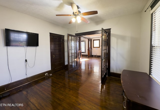 interior space with french doors, baseboards, wood-type flooring, and a textured ceiling