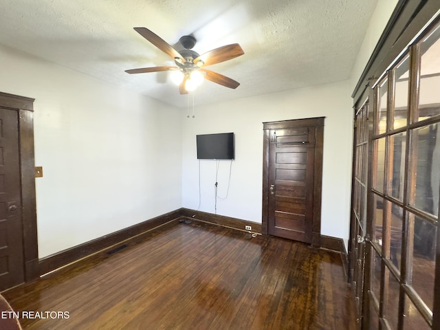 unfurnished bedroom featuring baseboards, a textured ceiling, and dark wood-style floors