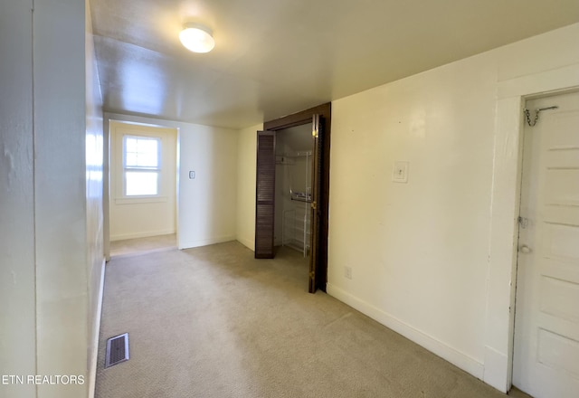 carpeted spare room with baseboards and visible vents