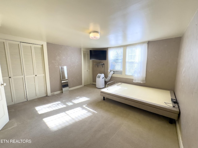 unfurnished bedroom featuring carpet flooring, a textured wall, and baseboards