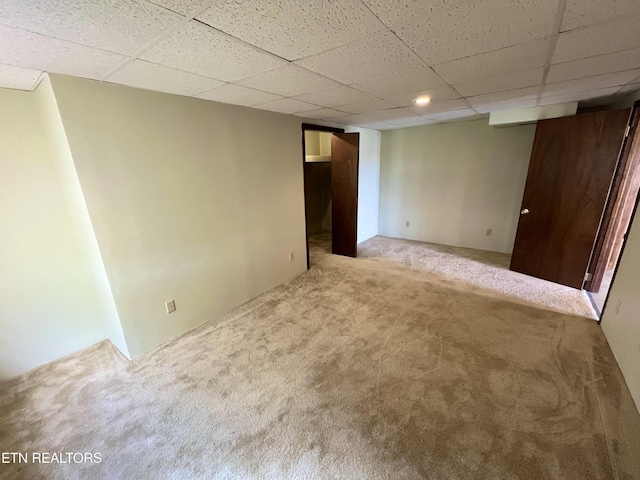 carpeted spare room with a drop ceiling