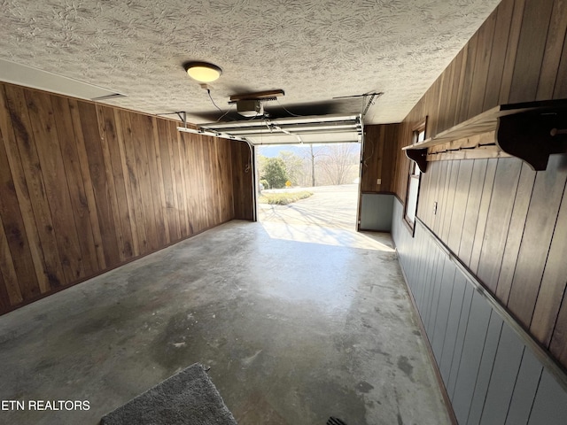 garage with wood walls and a garage door opener