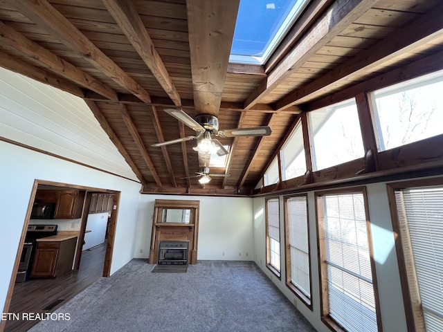 unfurnished living room featuring carpet, beam ceiling, wooden ceiling, a skylight, and high vaulted ceiling