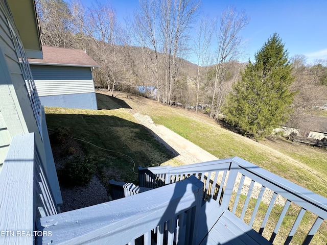 view of yard featuring a wooded view and a deck