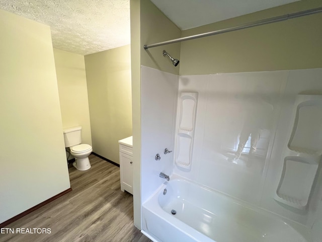 full bath with vanity, wood finished floors,  shower combination, a textured ceiling, and toilet