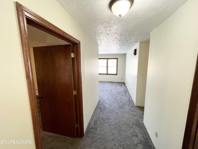 corridor featuring carpet floors and a textured ceiling