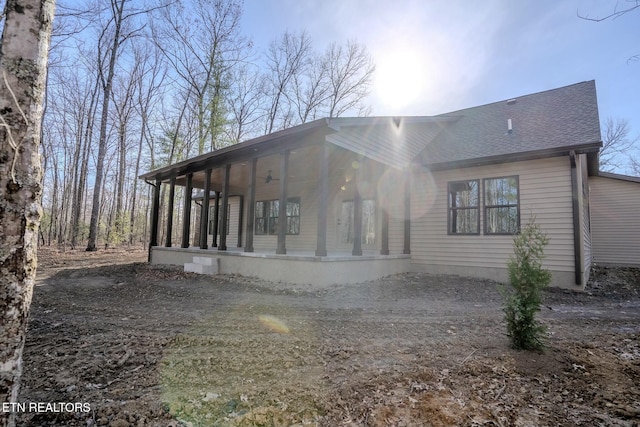 view of front of home with roof with shingles and a sunroom