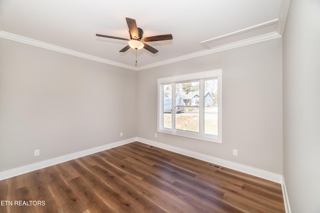 unfurnished room featuring visible vents, dark wood-type flooring, baseboards, and ornamental molding