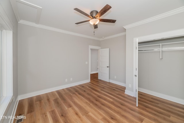 unfurnished bedroom featuring ornamental molding, a ceiling fan, a closet, light wood-style floors, and baseboards