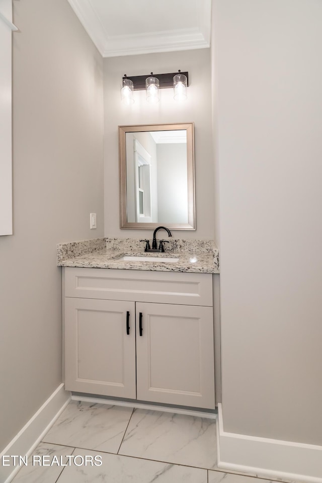 bathroom with marble finish floor, vanity, crown molding, and baseboards