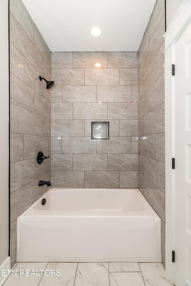 bathroom featuring marble finish floor and shower / tub combination