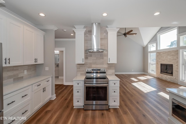 kitchen featuring open floor plan, stainless steel electric range oven, wall chimney exhaust hood, and light countertops