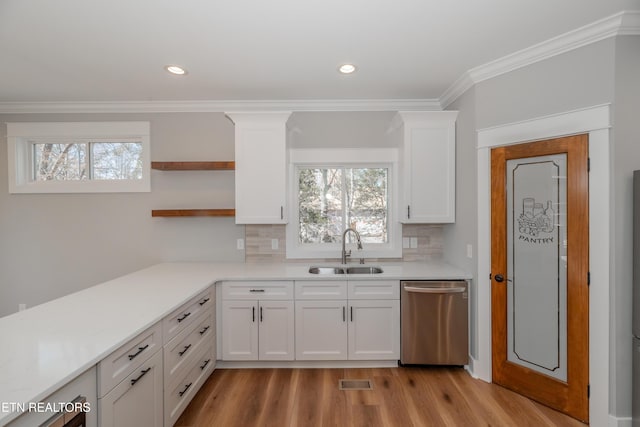 kitchen with a sink, crown molding, dishwasher, white cabinets, and open shelves